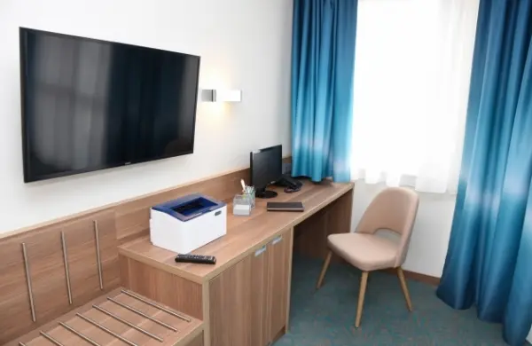 Szállodai szoba íróasztallal, nyomtatóval és monitorral